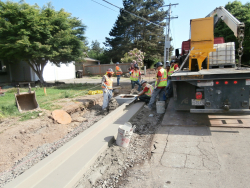 Construction workers building curb on Suncrest Drive.
